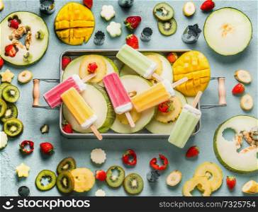 Various colorful popsicle ice cream, fresh fruits and berries in tray , top view. Summer food . Horizontal