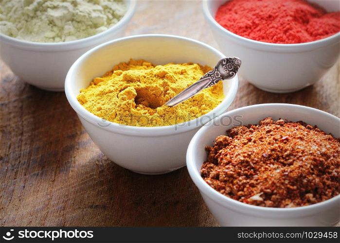 Various colorful spices on wooden table in bowls . Food and cuisine ingredients. Various colorful spices on wooden table in bowls . Food and cuisine ingredients.