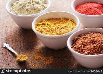 Various colorful spices on wooden table in bowls . Food and cuisine ingredients. Various colorful spices on wooden table in bowls . Food and cuisine ingredients.