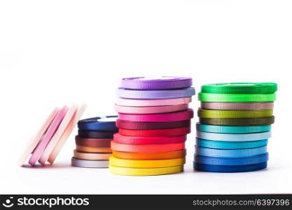 Various colors ribbon bobbins isolated on white. The ribbons isolated