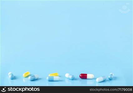 Various colour medication capsules. Blue background with copy space. Various medication capsules. Blue background with text space