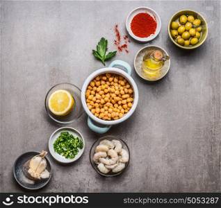Various cooking ingredients in bowls for Chickpea salad on gray concrete background, top view, copy space. Healthy , clean food or vegetarian cooking and eating concept