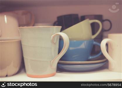 Various cups and mugs in a cupboard