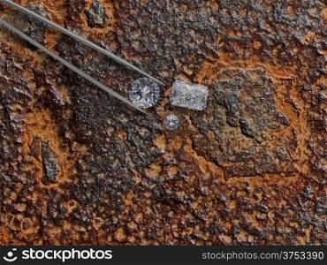 various cut cluster of diamonds in a working rusty plate