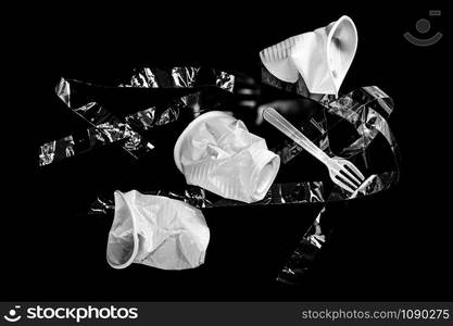 Various disposable crumpled plastic trash isolated on a black background. Concept of recycling plastic and ecology. Plastic waste.. Various disposable crumpled plastic garbage isolated on a black background. Concept of recycling plastic and ecology.