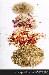 various dried herbs on old wooden table