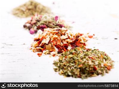 various dried herbs on old wooden table