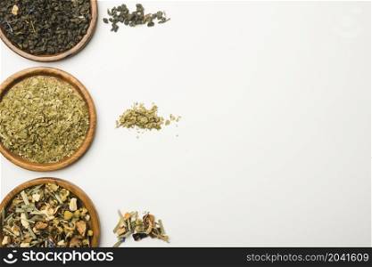 various dried herbs wooden plates against white background