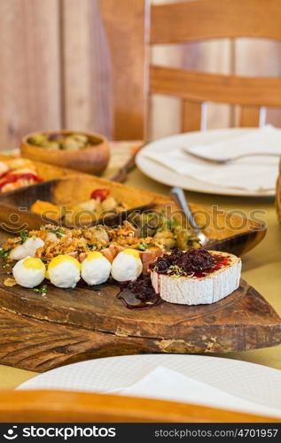 various entries on a table, cheese, tuna, chicken, jam, shrimps, mussel, little fried sardine