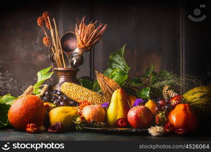Various fall fruits and vegetables on dark rustic kitchen table at wooden background, side view,copy space. Autumn harvest concept.