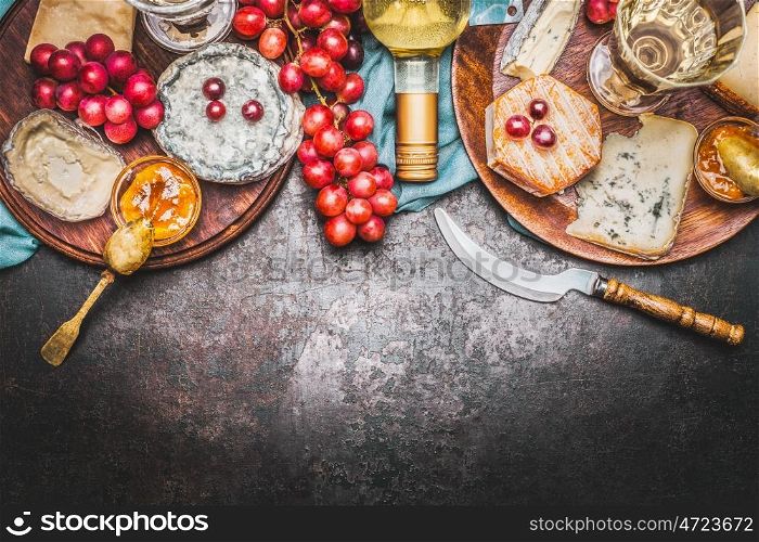 Various Fine cheese selection with Bottle of wine, Honey mustard sauce and grape on rustic background, top view, border