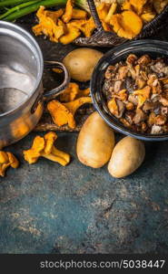 Various forest Mushrooms with potato on rustic kitchen table background, top view, place for text. Seasonal Autumn cooking concept