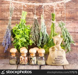 various fresh and dried herbs on wooden background