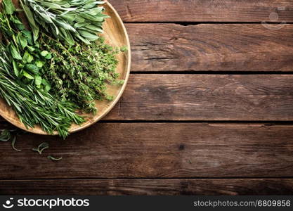 various fresh herbs, rosemary, thyme, mint and sage on wooden background