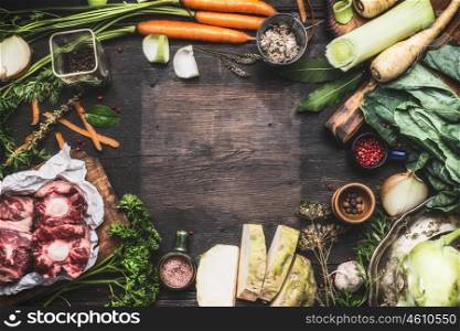 Various Fresh organic ingredients for Broth or soup cooking with vegetables and meat on dark wooden background, top view, frame