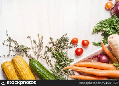 Various fresh organic vegetables on white wooden background, top view, border