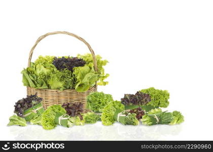 Various fresh salad vegetables in bamboo basket on isolated white background