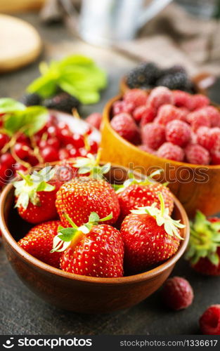 Various fresh summer berries, ripe strawberries, raspberries, blackberry