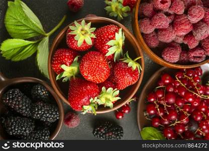 Various fresh summer berries, ripe strawberries, raspberries, blackberry