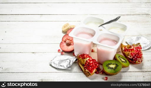 Various fruit yoghurts. On a white wooden table.. Various fruit yoghurts.