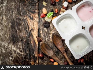 Various fruit yoghurts. On a wooden background.. Various fruit yoghurts.
