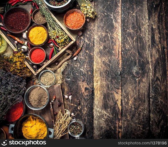 Various ground spices and herbs in an old tray. On a wooden background.. Various ground spices and herbs in an old tray.