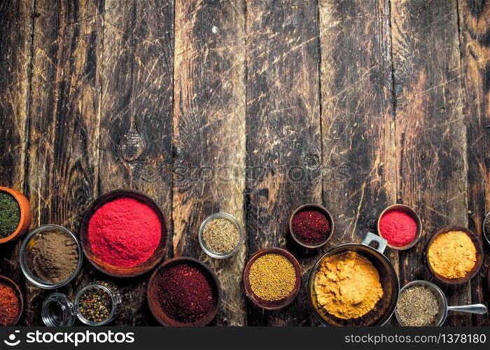 Various ground spices and herbs. On a wooden background.. Various ground spices and herbs.