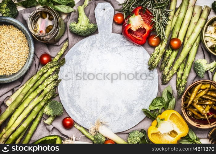 Various healthy vegetarian ingredients with Pearl barley around round cutting board, top view frame. Clean eating or diet food concept