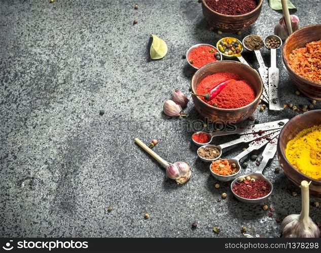Various herbs and spices with measuring spoons. On a rustic background.. Various herbs and spices with measuring spoons.