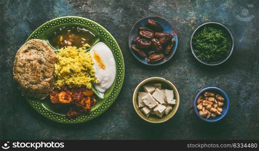 Various Indian foods in bowls on dark rustic background, top view