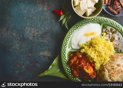 Various indian meal in bowl served on bamboo leaf on dark rustic background, top view, place for text