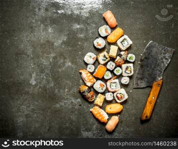 Various Japanese sushi rolls with an axe for cutting. On the stone table.. Various Japanese sushi rolls with an axe for cutting.