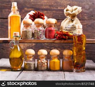 various jars of dried spices on wooden background