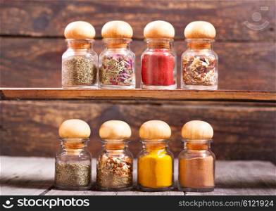 various jars of dried spices on wooden background