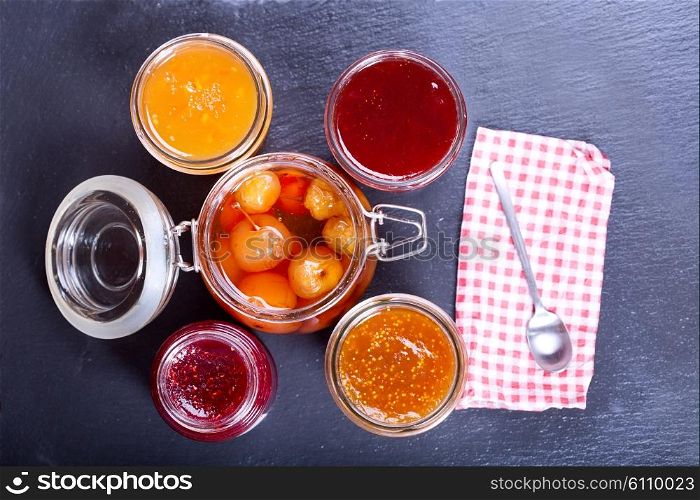 various jars of fruit jam on dark background