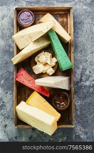 Various kind of cheese served in wooden box. Different kinds of cheeses