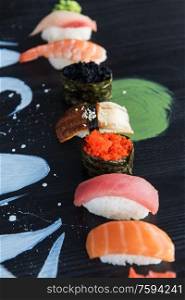 Various kinds of sushi served on wood black table.. Japanese seafood sushi set