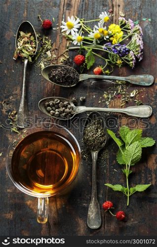 Various kinds of tea with honey, wild berry and flowers on wooden background