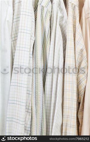 various male shirts on hangers in wardrobe close up
