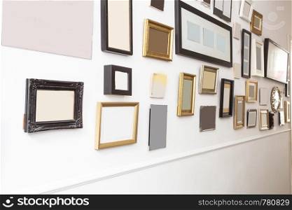 various many blank small picture frames on white wall, vintage retro design close-up. various many blank small picture frames on white wall, vintage retro design