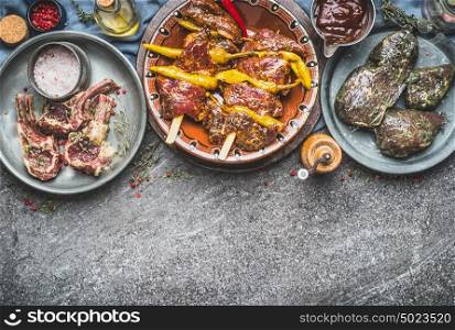 Various marinated meat in bowls for barbecue grilling or frying with spices on rustic background , kinds of meat, top view