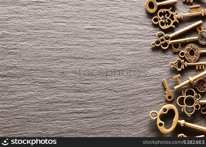 Various metal keys over slate background