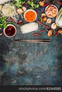 Various of asian cooking cooking ingredients and sauces with chopsticks on rustic background , top view , place for text. Asian food concept: Chinese or Thai cuisine.