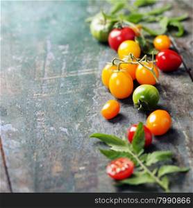 various of colorful tomatoes on wooden background. Cooking, Healthy Eating or Vegetarian concept. Background layout with free text space.