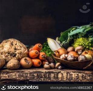 various of raw vegetables and field mushroom on old dark wooden table