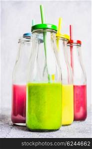 Various of smoothie and drinks in bottle with straws on light wooden background, side view. Healthy lifestyle and detox or diet food concept