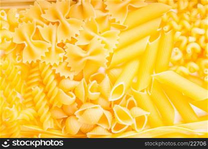 Various pasta types as a background on the table. Various pasta