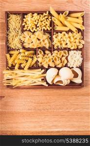 Various pasta types in the wooden box on the table