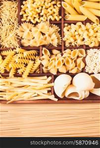 Various pasta types in the wooden box on the table. Various pasta