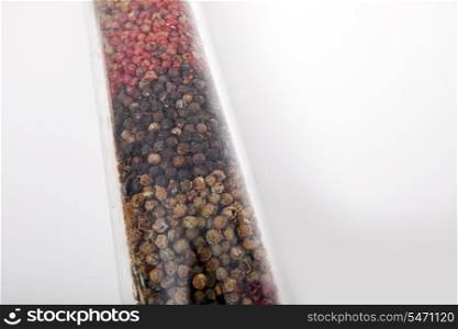 Various peppercorns in package against white background